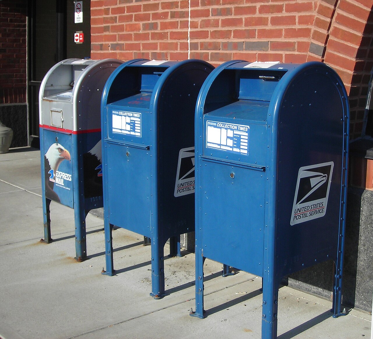 U.S. Postal Service collection boxes on a city street.